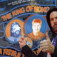Billy Mitchell, wearing a black suit and a stupid American flag tie, looks at the camera and gives a thumbs up gesture.